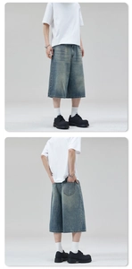 Close-up of vintage washed denim shorts showing wide-leg fit and whisker texture details
