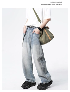 Détail d'un jean en denim bleu clair à jambes larges avec délavage rétro et style urbain