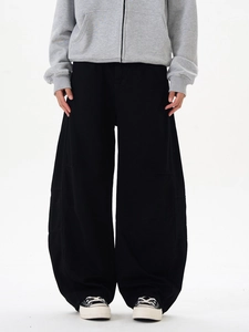 Détail d'un pantalon streetwear noir à jambe large avec coutures latérales et drapé fluide