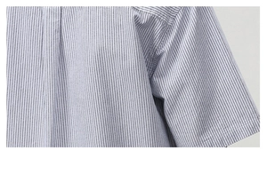 Close-up of the seam stitching and fine texture on blue white striped short sleeve shirt