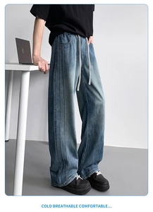 Detail of drawstring elastic waist and stitching on blue washed straight leg jeans