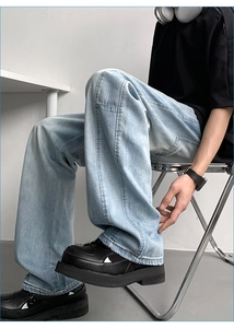 Relaxed fit light blue lyocell jeans shown in a casual seated pose with industrial style
