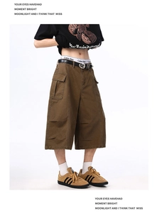 Detail shot of brown cargo shorts featuring flap pockets and pleated streetwear texture