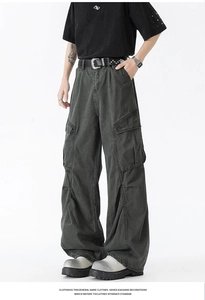 Detailed view of cargo pants featuring side flap pockets and charcoal gray pleated fabric