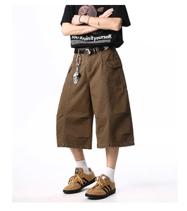 Detail of heavy cotton dark brown cargo shorts with large pockets and metal buckle belt