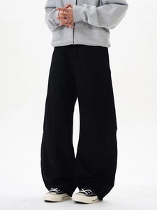 Détail du pantalon large noir montrant le drapé et la coupe décontractée sur modèle