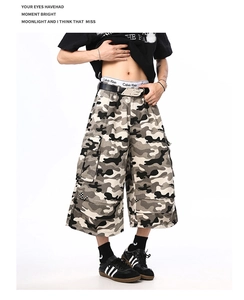 Detail view of grey camouflage cargo shorts with large side pockets and utility belt