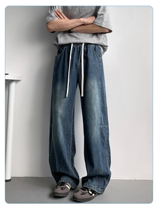 Detail of loose-fit dark blue ice silk jeans featuring an elastic drawstring waistband