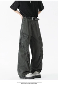 Detail view of baggy cargo pants featuring multi-pockets and pleated knee design in washed black