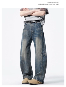 Gros plan sur un jean denim bleu délavé vintage avec coutures 3D et coupe ample