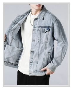 Detailed view of light blue washed denim jacket with classic collar and pocket texture