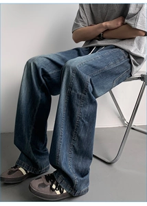 Detail of men's wide-leg ice silk jeans showing drape and vintage washed texture