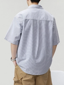 Back view of a casual loose-fit blue striped short-sleeve shirt with a box pleat detail