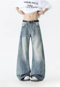 Détail d'un jean délavé vintage bleu clair à jambes larges avec ceinture tressée et chaîne