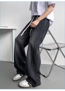 Detail of wide-leg denim pants featuring elastic waist with white contrast drawstrings