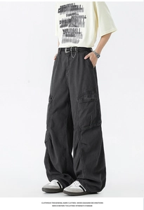 Detail view of washed black wide-leg cargo pants featuring oversized utility side pockets