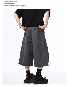 Detail view of the back of dark grey loose cargo shorts with elastic waist and flap pockets