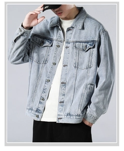 Detail of vintage washed denim jacket featuring metal buttons and classic chest pockets