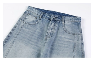 Détail de la taille et poche avant d'un jean bleu clair délavé avec bouton en métal