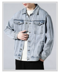 Close-up of vintage light blue washed denim jacket with metal buttons and chest pockets