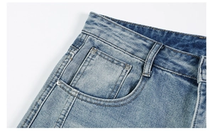 Détail du jean denim délavé bleu clair montrant la taille, la poche et les rivets en métal