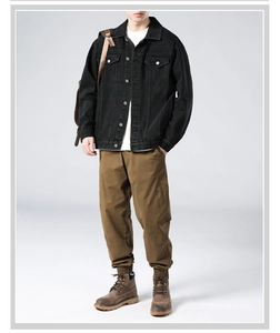 Full body view of vintage washed black denim jacket paired with brown cargo pants