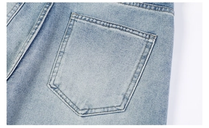 Détail macro de la couture de poche arrière sur un jean en denim délavé bleu clair