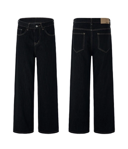 Detail of vintage washed black denim jeans with contrast stitching and leather patch