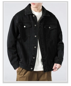 Detail of vintage black denim jacket featuring metallic buttons and classic chest pockets