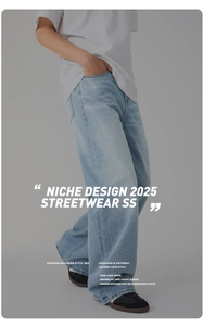 Detail of light blue washed denim jeans featuring vintage cat scratch texture and loose fit