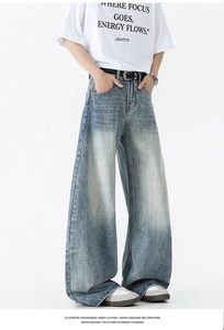 Détail macro d'un jean délavé bleu clair avec moustaches et texture vieillie usée