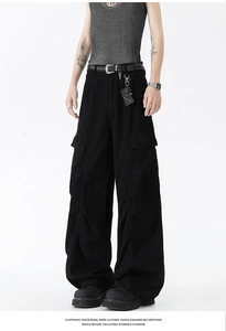 Detailed close-up of large flap pockets on black vintage wide-leg cargo trousers for men