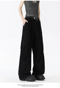 Detail view of retro black cargo pants with side pockets and a vintage woven belt