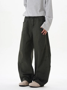 Détail du pantalon large vert armée avec plis structurés aux genoux et design drapé