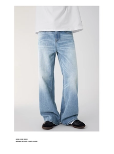 Detail of light blue washed denim jeans showing wide-leg fit and premium cotton texture