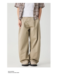 Detail of khaki wide-leg trousers showing pleated waist and relaxed fit silhouette