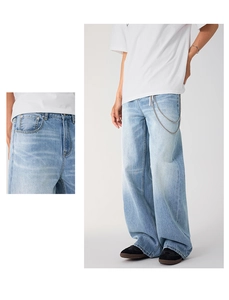 Detail of light blue wide-leg jeans with vintage wash and double metal waist chains