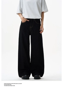 Detail of black wide-leg denim pants featuring high waist and contrast yellow topstitching