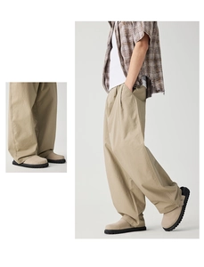 Detail of khaki wide-leg work pants featuring side pleats and premium cotton fabric texture
