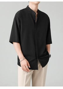 Detail of men's black short-sleeve shirt with stand collar and smooth fabric texture