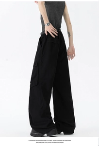 Detail of black cargo pants featuring large utility flap pockets and street style cut