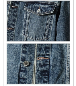 Close-up of vintage washed denim jacket showing flap pockets and metal buttons