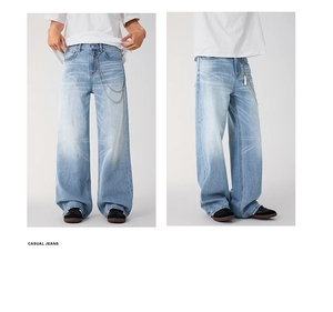 Detail of light blue washed denim jeans with decorative double silver waist chains