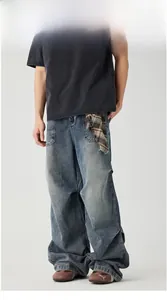Detail of vintage washed wide-leg jeans featuring unique brown plaid fabric patchwork