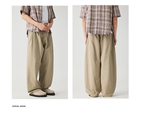 Detail view of khaki pleated cargo pants featuring a wide-leg cut and relaxed fit for men