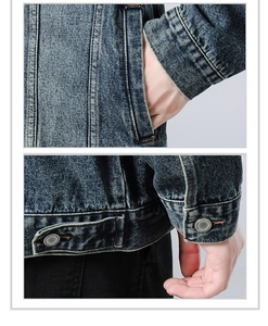 Detail view of vintage wash denim jacket with metal buttons and stitched pockets
