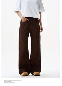 Detail view of high-waist dark brown wide-leg denim trousers with premium metal button