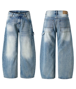 Detail shot of light blue washed denim jeans with vintage whiskering and back leather patch