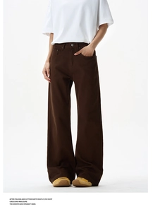 Detail showing high-waisted deep brown wide-leg pants with premium stitching quality