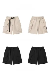 Detail view of khaki and black cargo shorts with buckle belt and large flap pockets